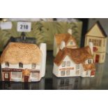 A mixed lot to include miniature cottages, a tin etc