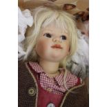 A boxed Annette Himstedt doll, a girl in red tunic dress