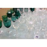Assorted glassware to include green glass glasses, clear glasses, champagnes and liquor glasses