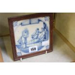 An 18th Century Dutch Delft blue and white tile painted with Christ in the Temple, with wooden