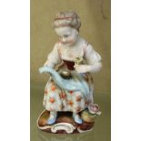 A 19th Century figure of young girl holding a flower with a birds nest on her lap 11cm high, with