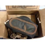 A WWII gas mask in original box and a volt meter