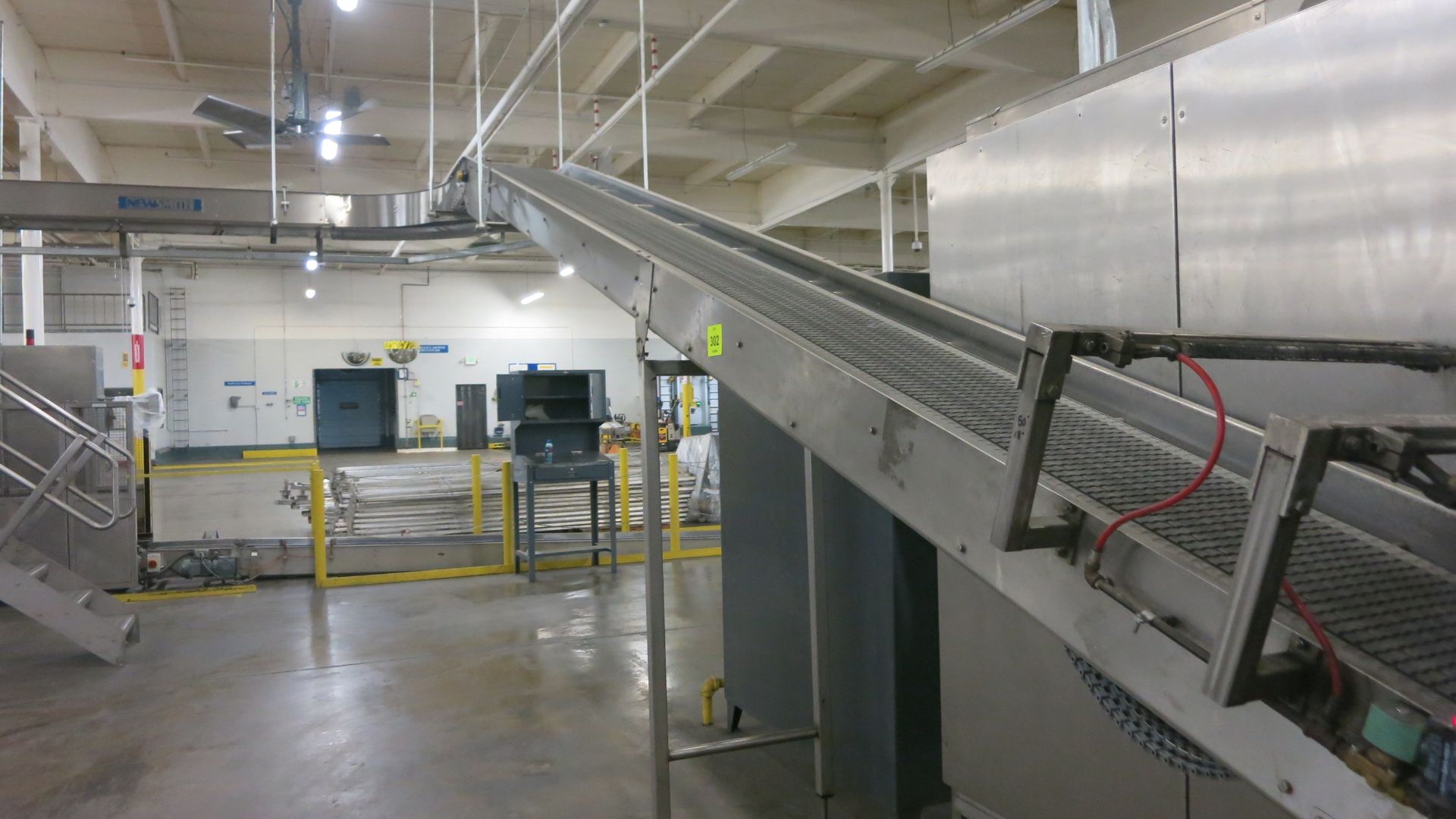 Newsmith inclined empty tray conveyor, 50' long, 18" plastic belt, 24" wide, (1) 90Â° turn, (1)