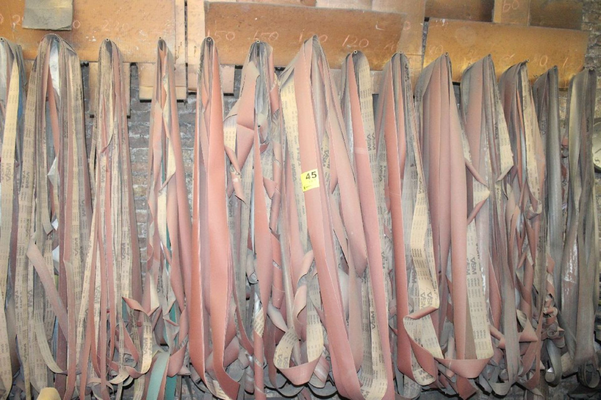 LOT-ASSORTED ABRASIVE BELTS ON WALL