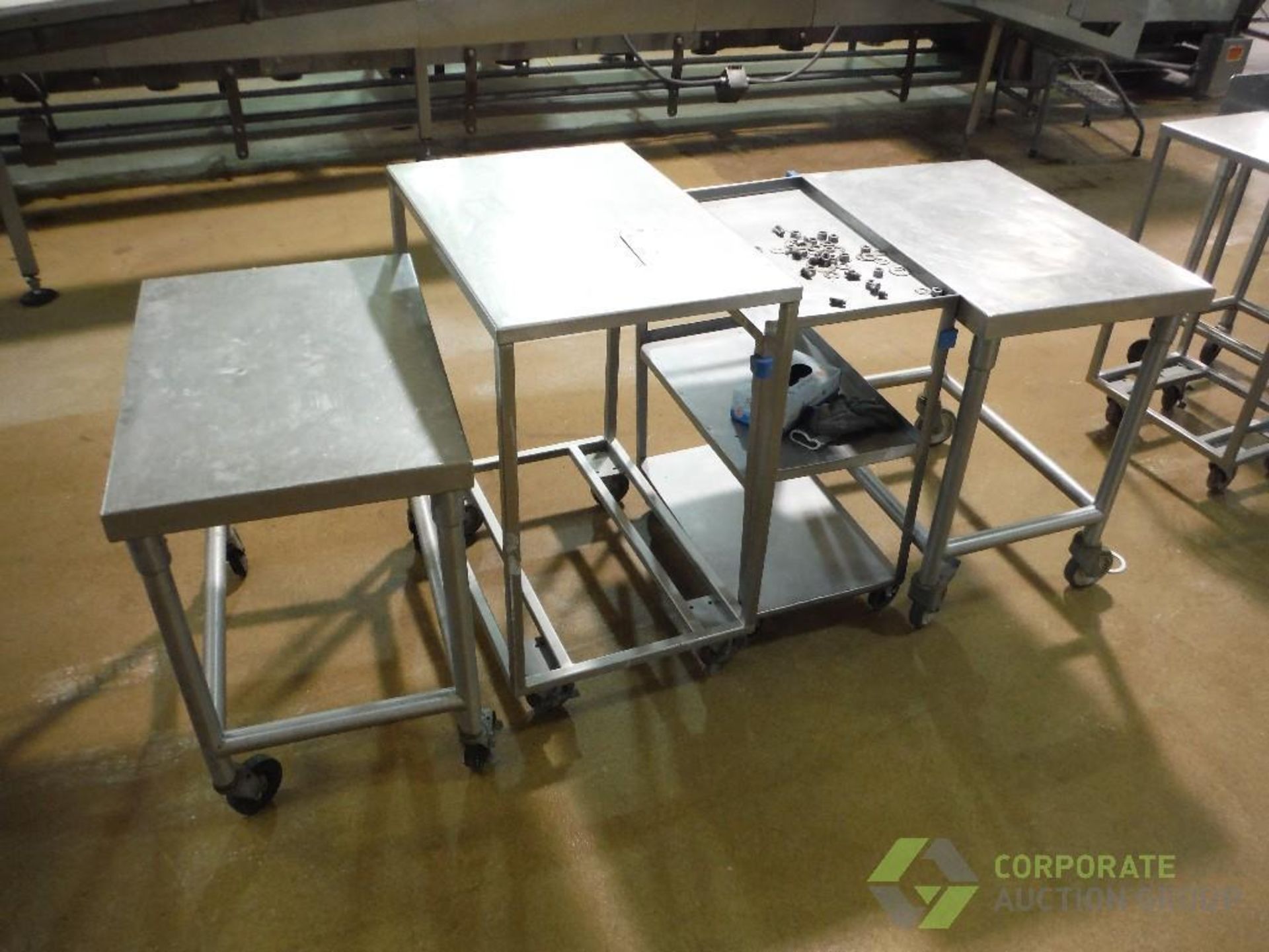 (4) assorted SS tables, approx. 30 in. long x 21 in. wide x 30 in. tall, on casters (LOT)