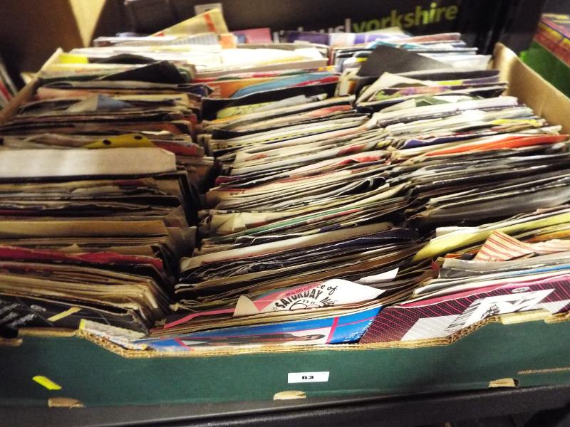 A box containing in excess of 200 vinyl single records predominantly pop and rock music from the