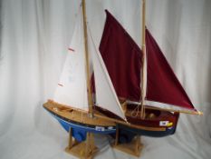 Two model yachts on stands,