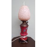 Decorative pink and leaf decorated oil lamp with pink glass shade converted to electricity