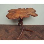 Rustic occasional table made from a slab of yew wood mounted on a tripod branch from the same tree