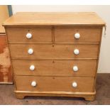 Victorian stripped pine chest of 3 long and 2 short drawers with white porcelain knob handles,