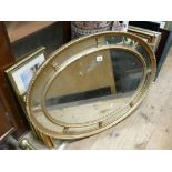 Oval gilt framed wall mirror with decorative panels