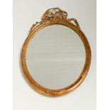 Oval wall mirror in ribbon decorated gilt frame
