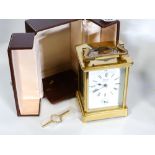 A modern French striking carriage clock in brass and glass case with carrying case