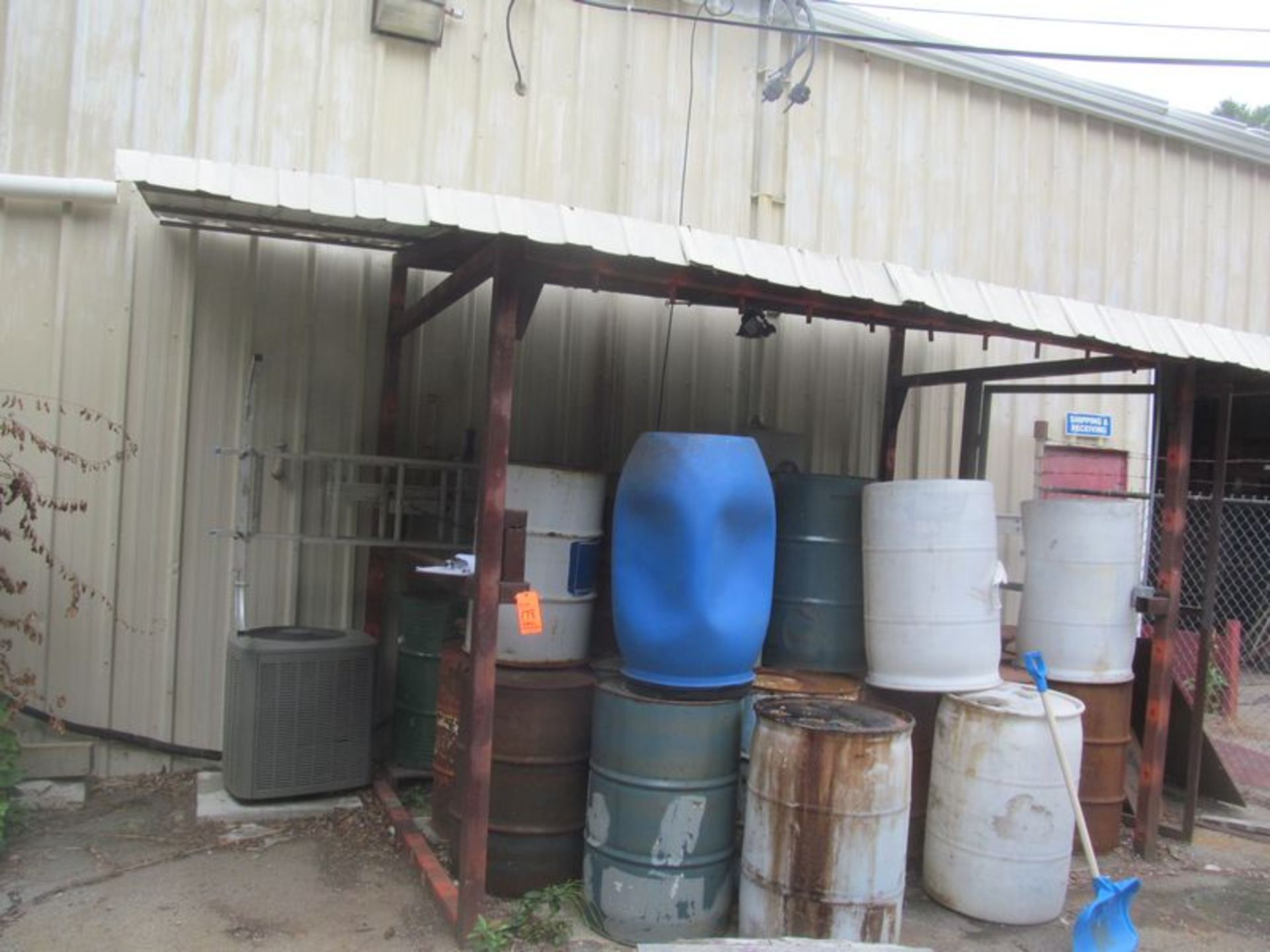 Metal framed shelter 11' x 8' x 9 1/2' high with empty drums