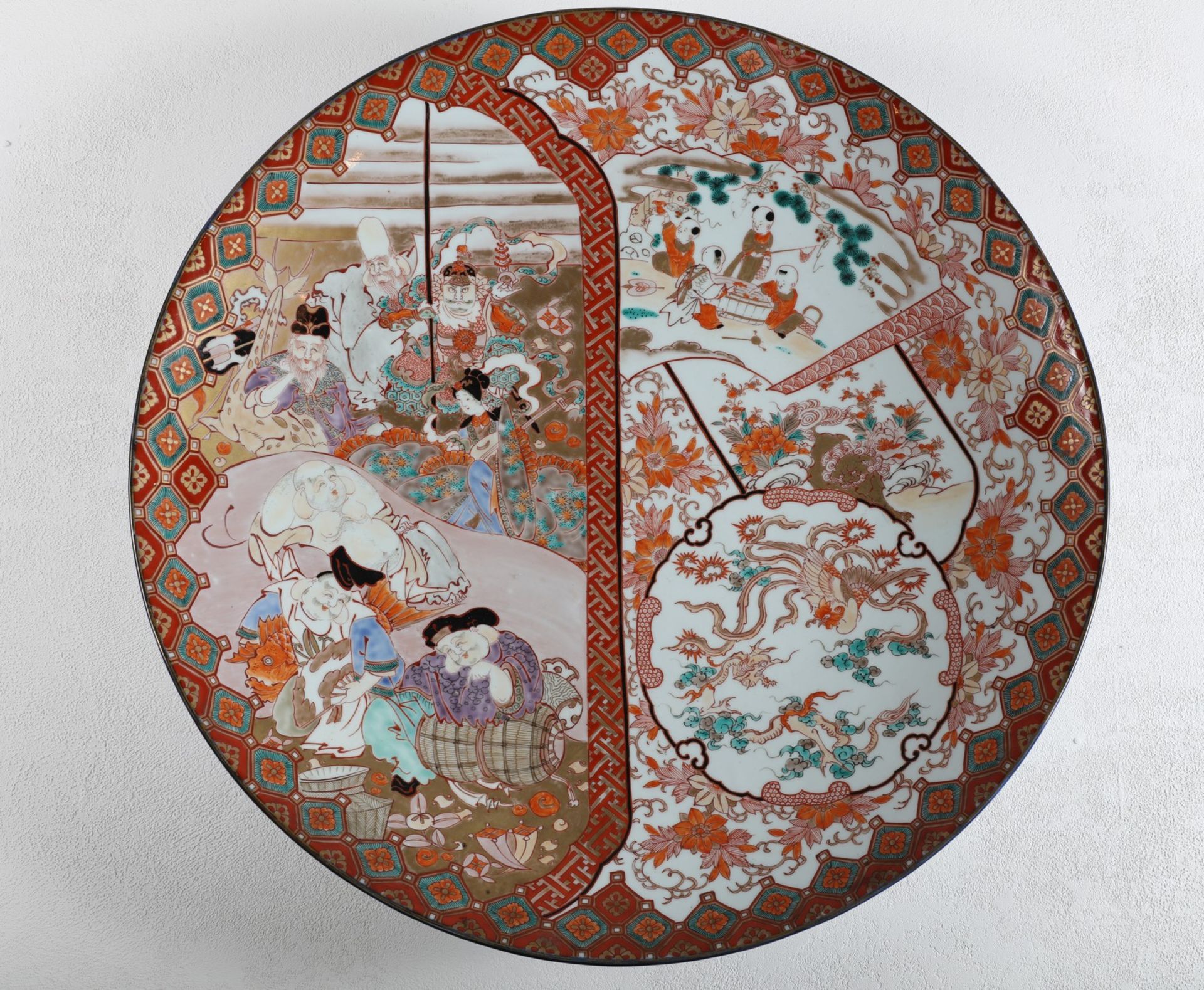 Arte Giapponese. A very large Kutani pottery dish enamelled and gilted with ladies, children,
