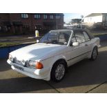 A 1985 Ford Escort XR3i cabriolet, registration number C142 NTV, white.