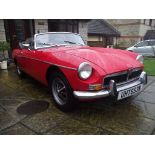 A 1974 MG B roadster, registration number UHT 653N, Tartan red.