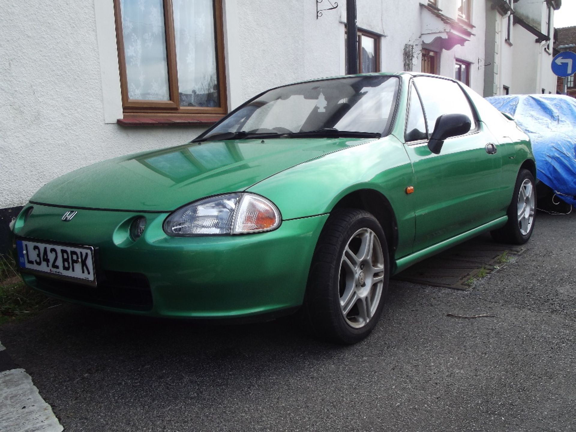 A 1993 Honda CRX, registration number L342 BPK, green.