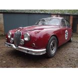 A 1963 race prepared Jaguar Mk II 3.8 litre, registration number 928 CLJ, red.