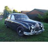 A 1957 Jaguar 3.4 Mk I automatic saloon, registration number 682 UYB, British Racing green.