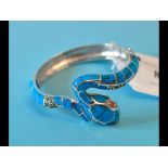 A silver and turquoise snake bangle