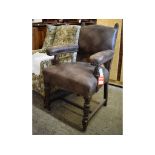 A leather upholstered oak carver chair, on turned and carved front legs,