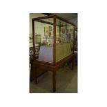An early 20th century walnut museum type cabinet, on a stand,