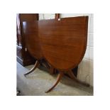 A Regency style mahogany twin pillar dining table, inset an extra leaf,