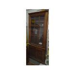 A cabinet, built for a recess, having a single glazed door above a pair of panel doors,