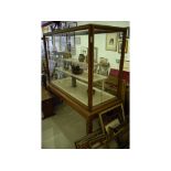 An early 20th century walnut museum type cabinet, on a stand,