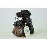 A novelty painted metal inkwell, in the form of a dog, carrying puppies in a satchel,