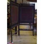 An Indian carved wood two fold screen, with tapestry panels,