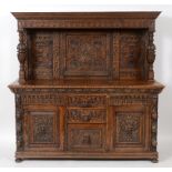 A late 19th century Anglo-Flemish oak sideboard, carved grotesque masks and foliage,