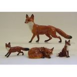 A Beswick Fox, curled, 1017, three other foxes, 1016A, 1748 and 1440, a Beswick Stag, lying, 954,