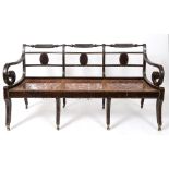 A Regency simulated rosewood triple chair back settee, on eight sabre legs and with brass casters,