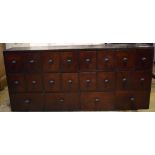 A stained pine chemists style chest, with an arrangement of 20 drawers,