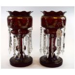 A pair of large ruby glass lustres, with gilt and enamel decoration and prismatic drops,