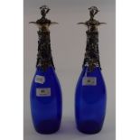 A pair of blue glass bottles, with plated foliate mounts,