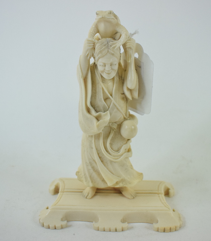 A Japanese carved ivory figure, holding a toad aloft, on a plinth base, 14.