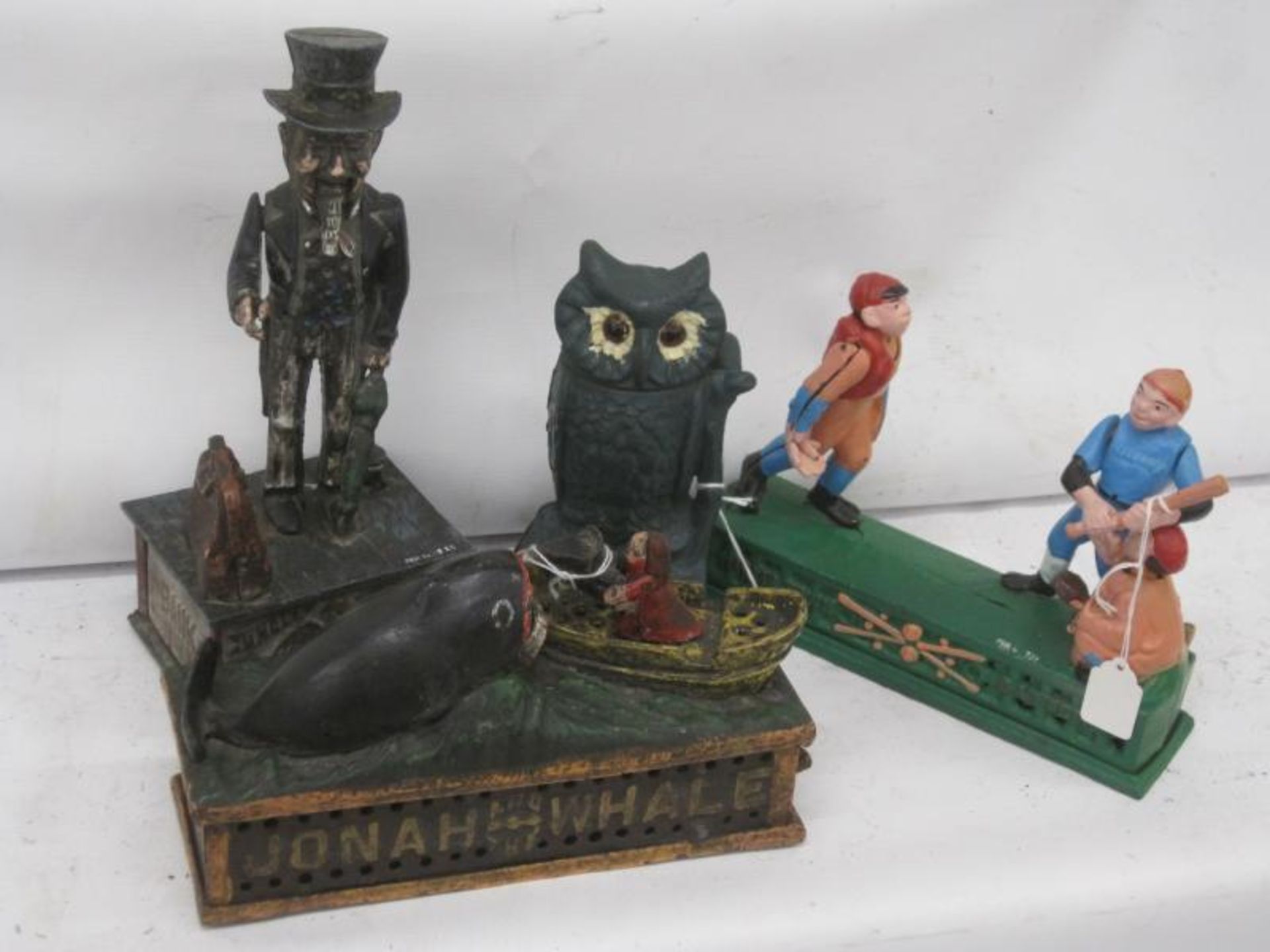 Reproduction cast iron money boxes, Jonah, Uncle Sam, Home Town Battery and Owl (ex-Holkham Hall)