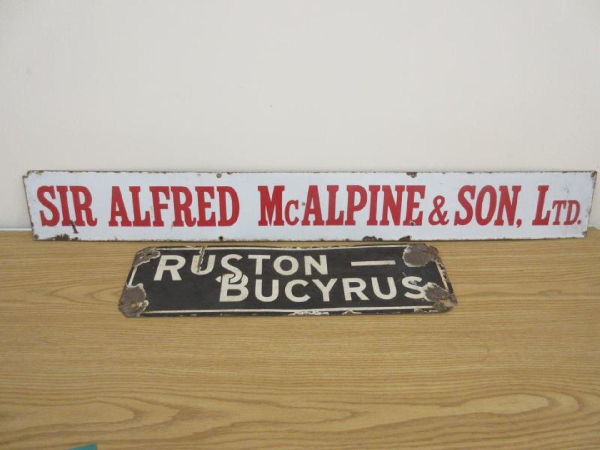 Enamel signs: Sir Alfred McAlpine & Son Ltd 42 x 6 inches t/w Ruston-Bucyrus 25 x 7.5 inches