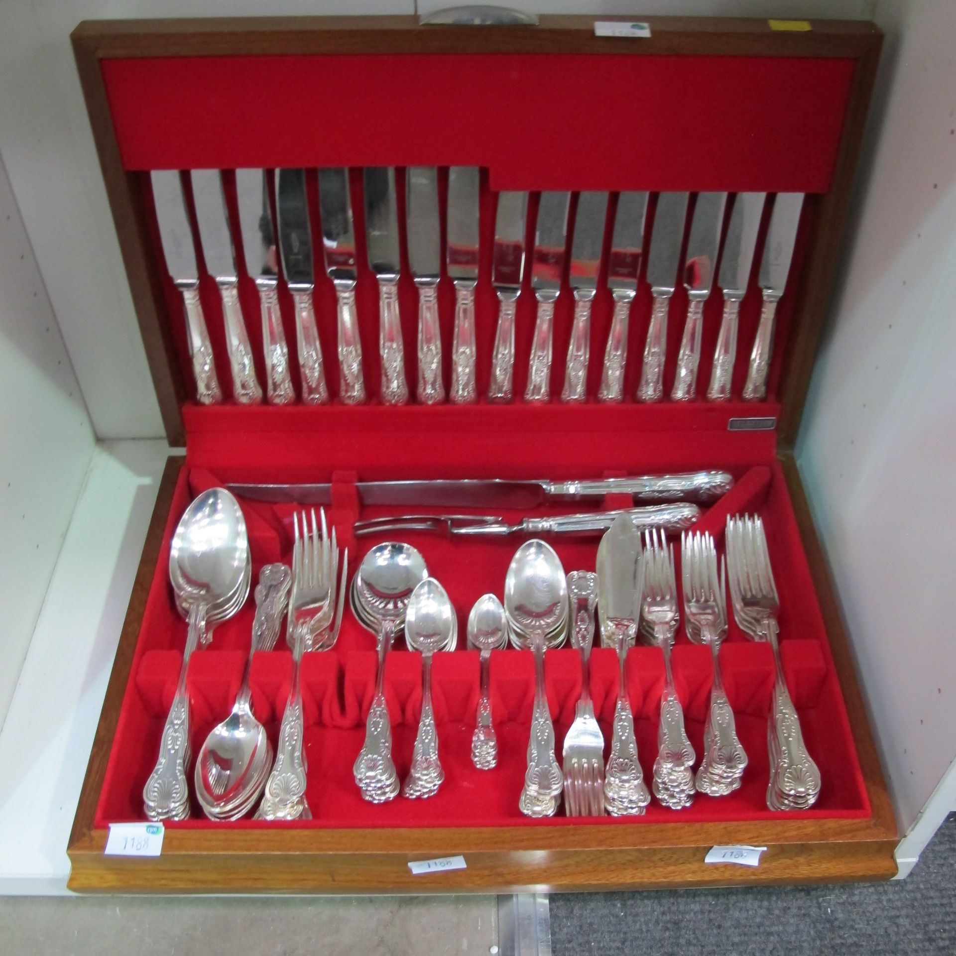 A wooden box with a red felt interior containing 89 pieces of silver plated dining cutlery and