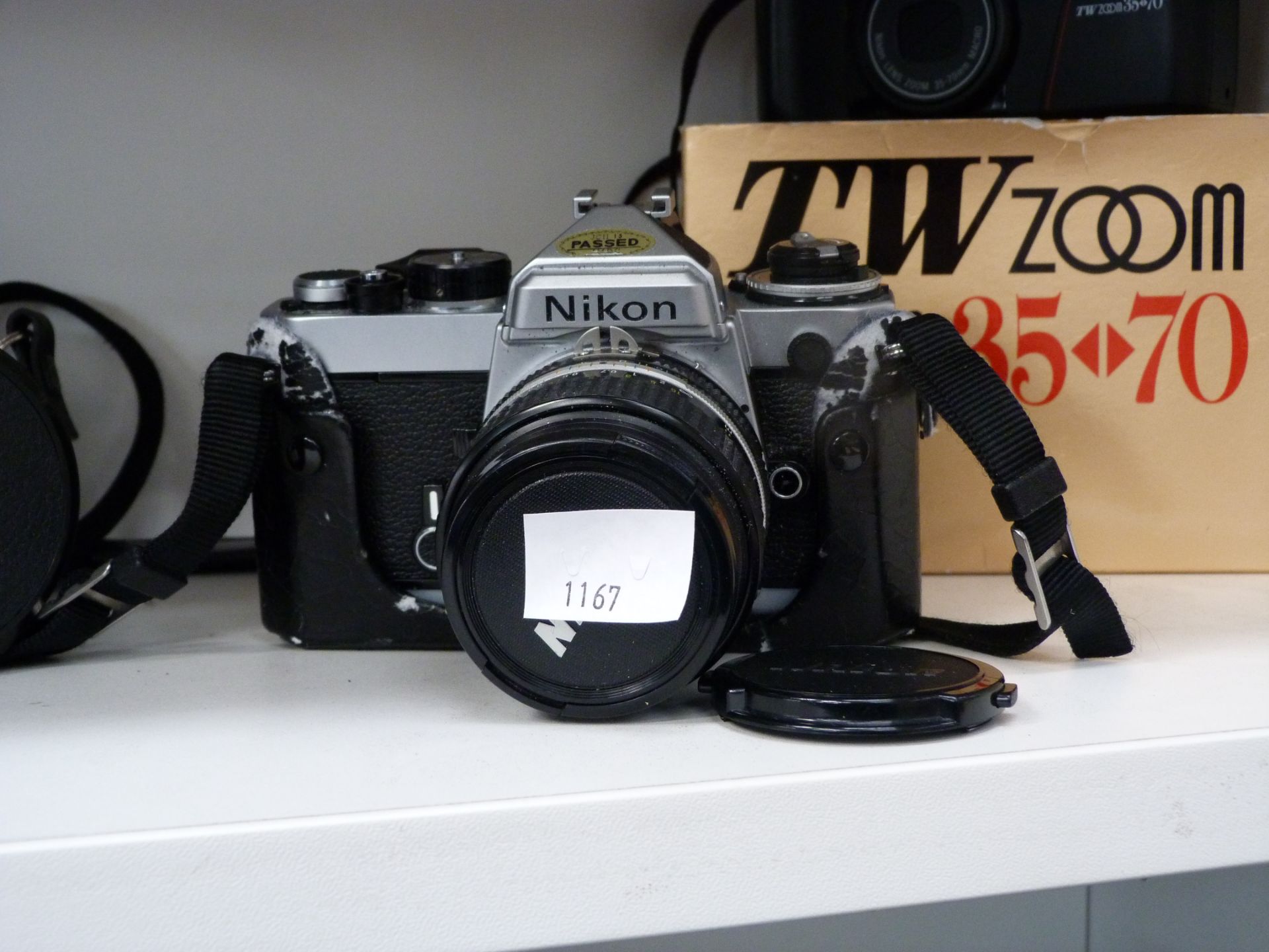 A Canon AV1 35mm camera, Nikon FT 35mm camera and a Nikon TW Zoom 35-70 (est £90-£120) - Image 2 of 2