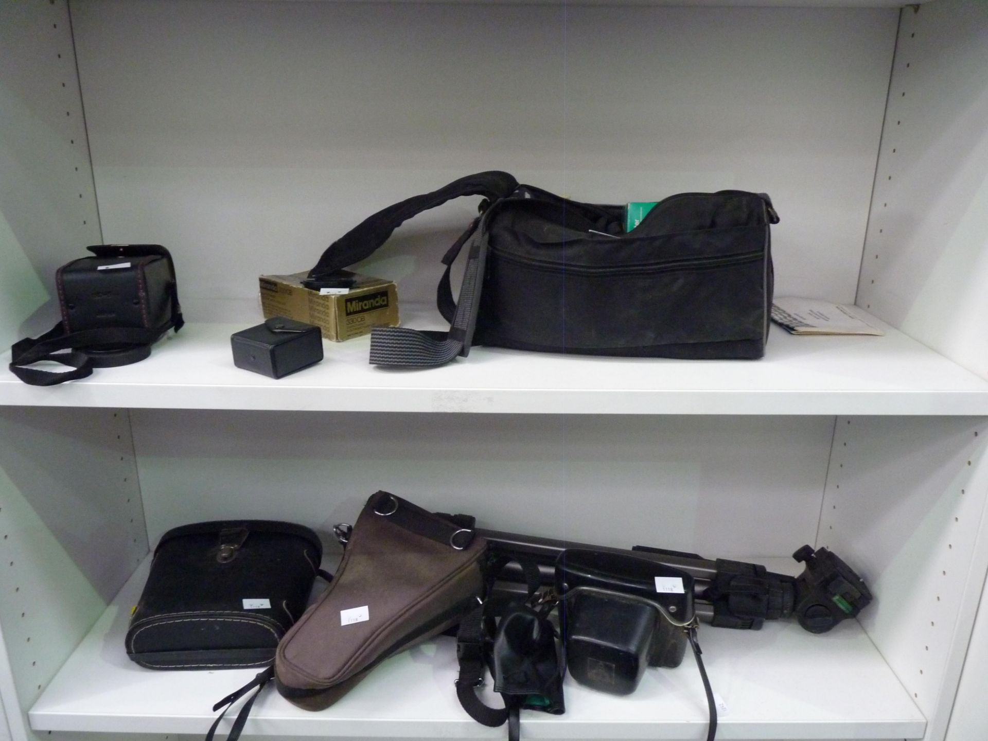 A collection of cameras/camera equipment to include a Praktika MTL 50+ lens, tripod, soft case &