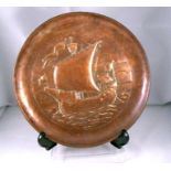 A Newlyn Arts and Crafts copper dish embossed with a galleon 22cm diameter