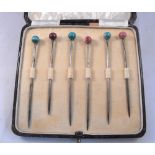 A set of six silver cocktail sticks, cased