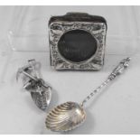 A silver photograph frame, a silver apostle spoon and a South African silver brooch in the form of a