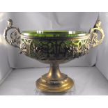 A WMF gilded two handled pedestal centre bowl with pierced and fruit decoration having a green glass