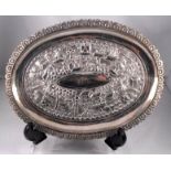 An Indian white metal oval dish, decorated figures and buildings, initialled "JFC" 140g 22cm x 16cm