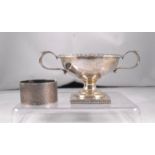 A George V two handled silver salt, London 1919, 6cm high and a silver napkin ring 97g